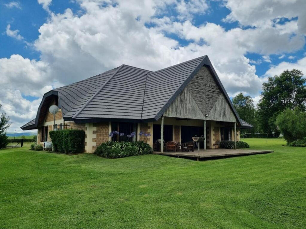 Plain Champagne Guest Farm thatched farmhouse with Drakensberg mountain view