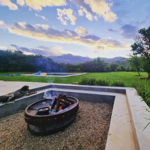 Outdoor Fire Pit at Plain Champagne Guest Farm Outdoor fire pit at Plain Champagne Guest Farm with mountain views and open lawn at sunset