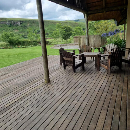 Covered Deck and Outdoor Seating Area Covered wooden deck at Plain Champagne Guest Farm with outdoor seating overlooking lawns and surrounding hills